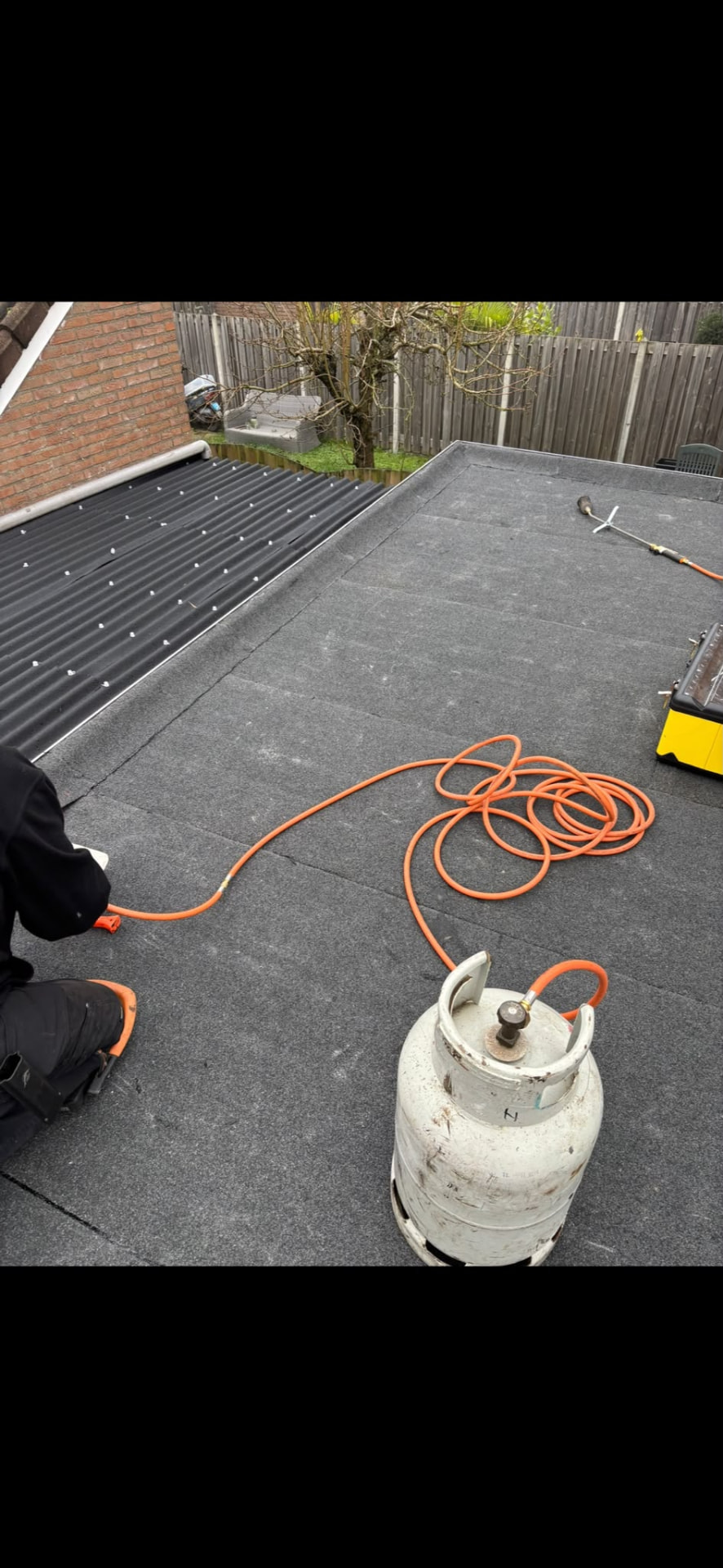 Nieuw bitumen plat dak op garage met zinken daktrim