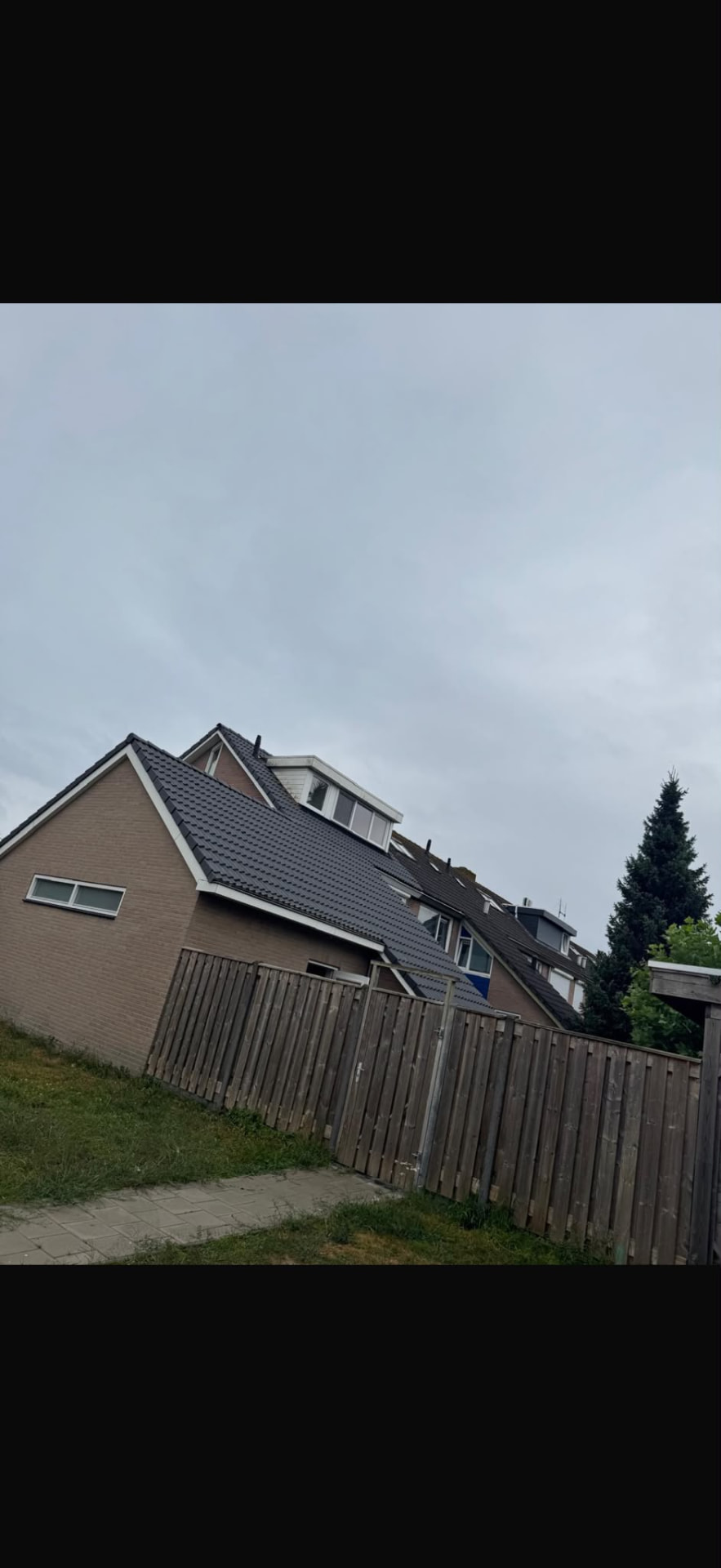 Woning met vernieuwd zwart pannendak en dakkapel