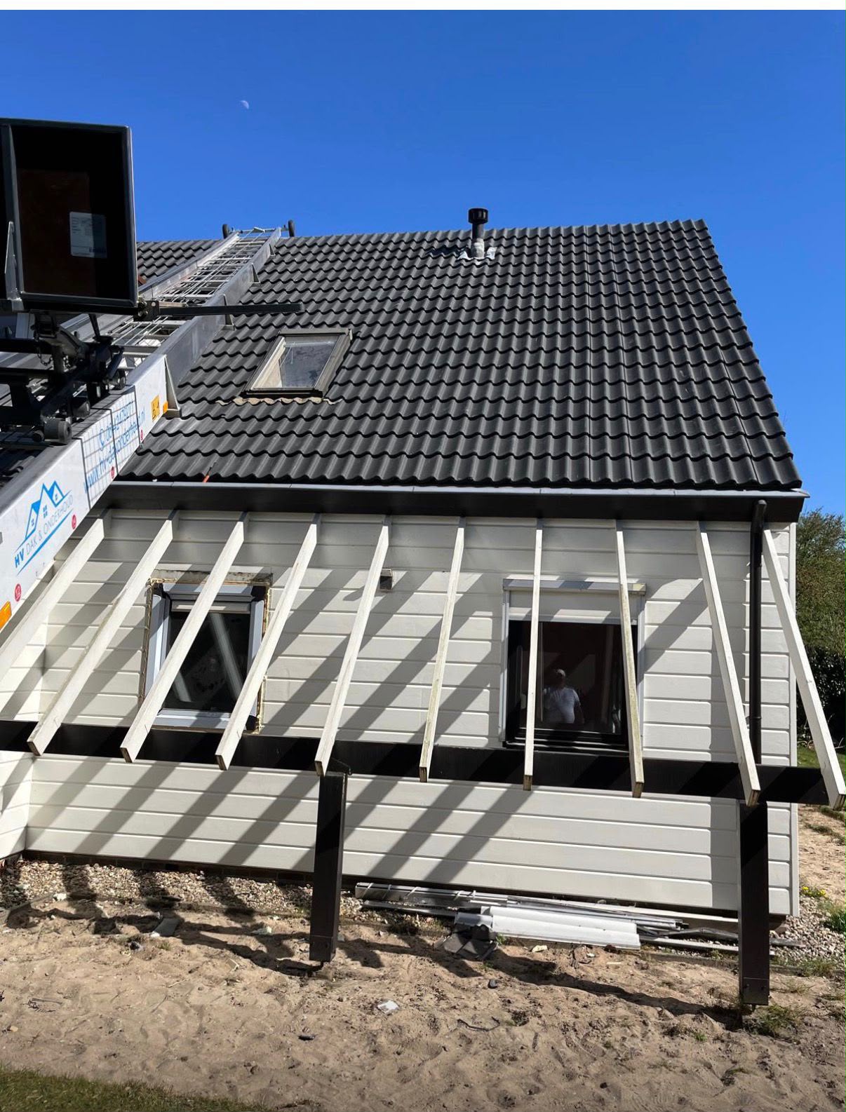Dakdekkers leggen nieuwe dakpannen op een woonhuis